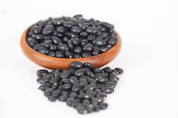 Black beans in wooden bowl on white background. Vegan vegetarian healthy food.