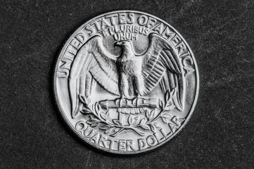 Close up of quarter dollar coin on black background - business concept