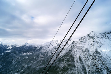 Paesaggio montuoso innevato con cavi acciaio funivia sospesi nel vuoto