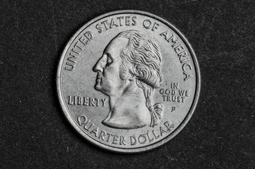 Close up of quarter dollar coin on black background - business concept