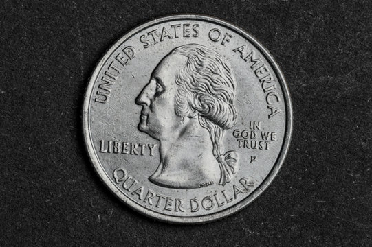 Close up of quarter dollar coin on black background - business concept