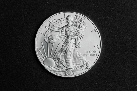 Close up of one dollar silver coin on black background - business concept