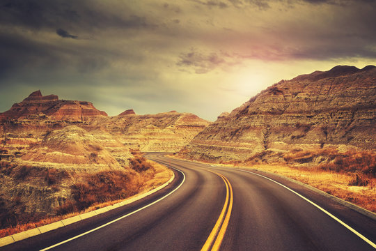 Scenic road at sunset, color toned picture, Badlands National Park, South Dakota, USA.