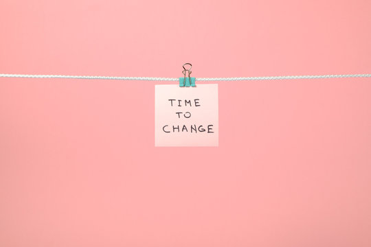Pink paper note hanging on the string with text “Time to Chang
