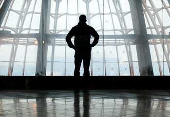 Fototapeta na wymiar Silhouette of man standing over window
