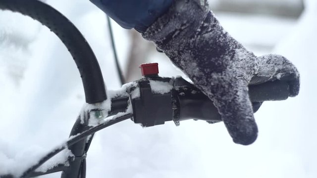 Man's hand pushing the lever on a snowmobile