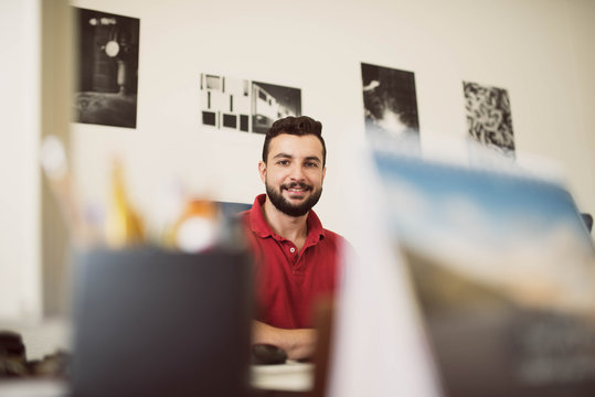Man working in office smiling and looking at view