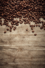 Vintage roasted coffee beans background over burlap fabric