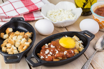 Unbaked eggs with marinara and feta.