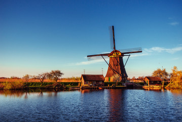 Colorful spring day with traditional Dutch windmills canal in Ro