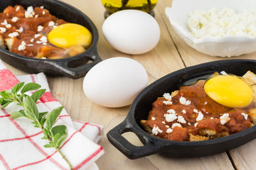 Unbaked eggs with marinara and feta.