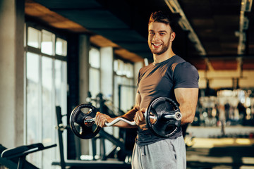 Handsome man doing biceps lifting in a gym © djile