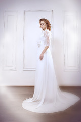 Portraits of a young bride on light background