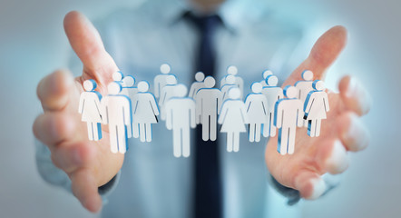 Businessman holding 3D rendering group of people in his hand