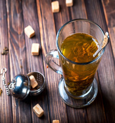 Hot tea in a transparent mug on wooden background