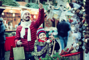 Little girl with dad buying decorations for Xmas