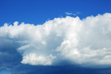 Obraz premium Blue sky, big cloud approaching abrupt change in the weather