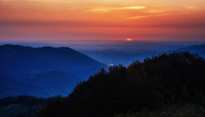 Red sunset in the mountains landscape with sunny beams. Carpathi