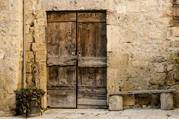 Fototapeta na wymiar Wooden door with pathway in stone wall