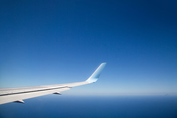 Fototapeta na wymiar Flugzeugtragfläche mit strahelnd blauen Himmel