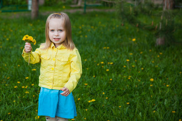 Little pretty girl showing her bouquet of dandelions