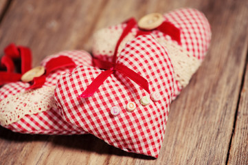 Hearts made of cloth on a wooden background