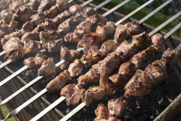 Grilling marinated meat on a brazier