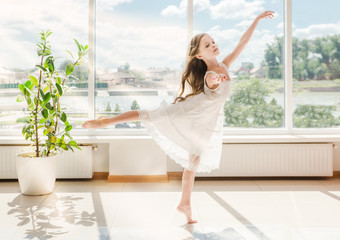 Cute little ballerina in white ballet costume is dancing © jutaphoto