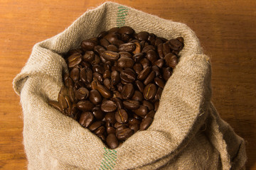 Kaffeebohnen und Kaffeetasse auf weißem Leinen mit Löffel und Jutesack