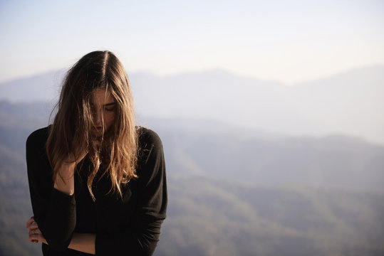 Woman with eyes closed standing against mountains