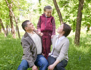 happy family and child in summer park, beautiful landscape with trees and green grass