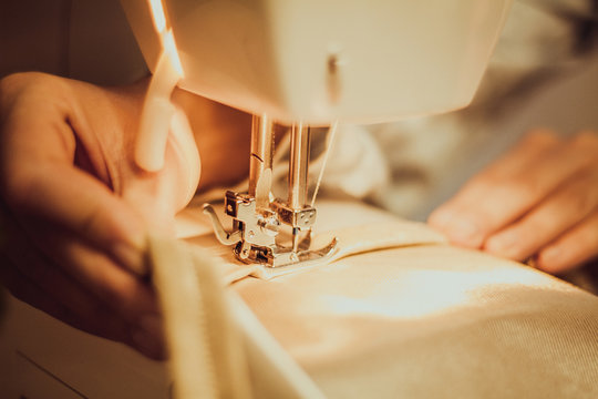 close-up hands of a seamstress at the sewing machine, toning 
