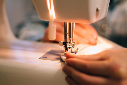 close-up hands of a seamstress at the sewing machine