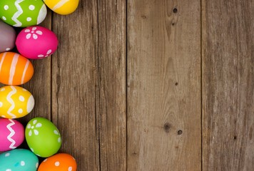Colorful Easter egg side border against a rustic wood background