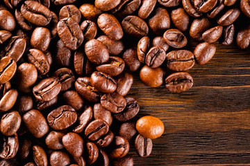 Macro image of roasted coffee beans at brown textured wooden boa