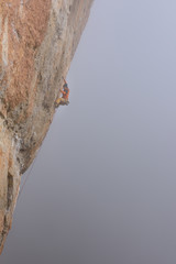 Fototapeta na wymiar Outdoor sport. Rock climber ascending a challenging cliff. Extreme sport climbing. 