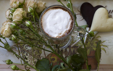 cappuccino with chocolate hearts and rose on a tray