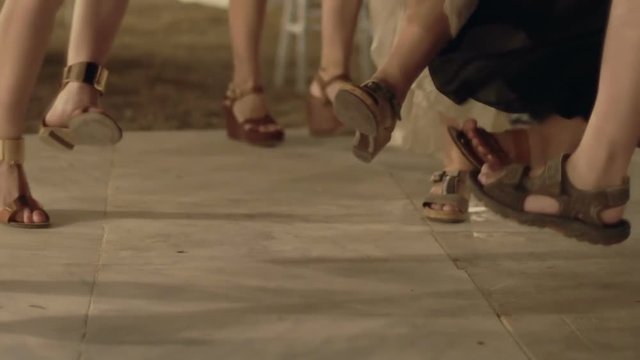 Attractive women in sexy heels dancing to greek folk song at night party