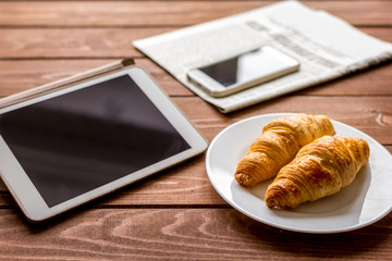Businessman lunch at home with croisant and devices