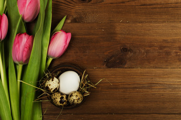Chicken and quail eggs with tulips. Easter background