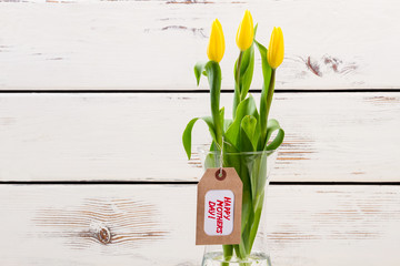 Mother`s Day tag and tulips. Flowers in vase and label. How to decorate a bouquet. Lovely present for dear mom.