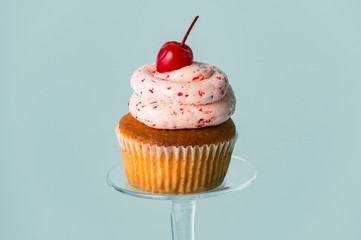 cherry cupcake on blue background - Powered by Adobe