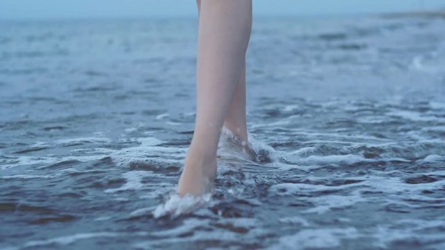 Feet girl stepping on the sea