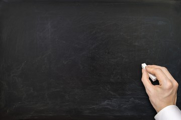 Hand of teacher and empty blackboard.
