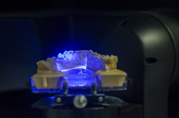 Dental technician scanning a dental cast model in a 3D surface s