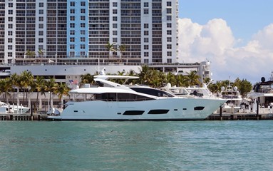 Fototapeta na wymiar White motor yacht moored at a condominium marina complex in Miami Beach,Florida