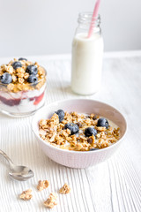 Homemade fitness granola with yoghurt and berries on white kitchen background