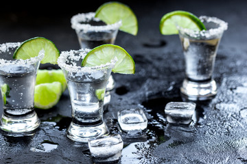 Alcohol party with tequila, ice and salt on black background