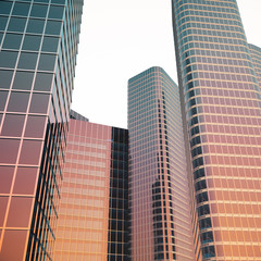 Fototapeta premium Bottom view of modern skyscrapers in business district in evening light at sunset. Industrial architecture, business construction and estate financial concept. 3d rendering