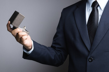 Business man hand holding box with ring